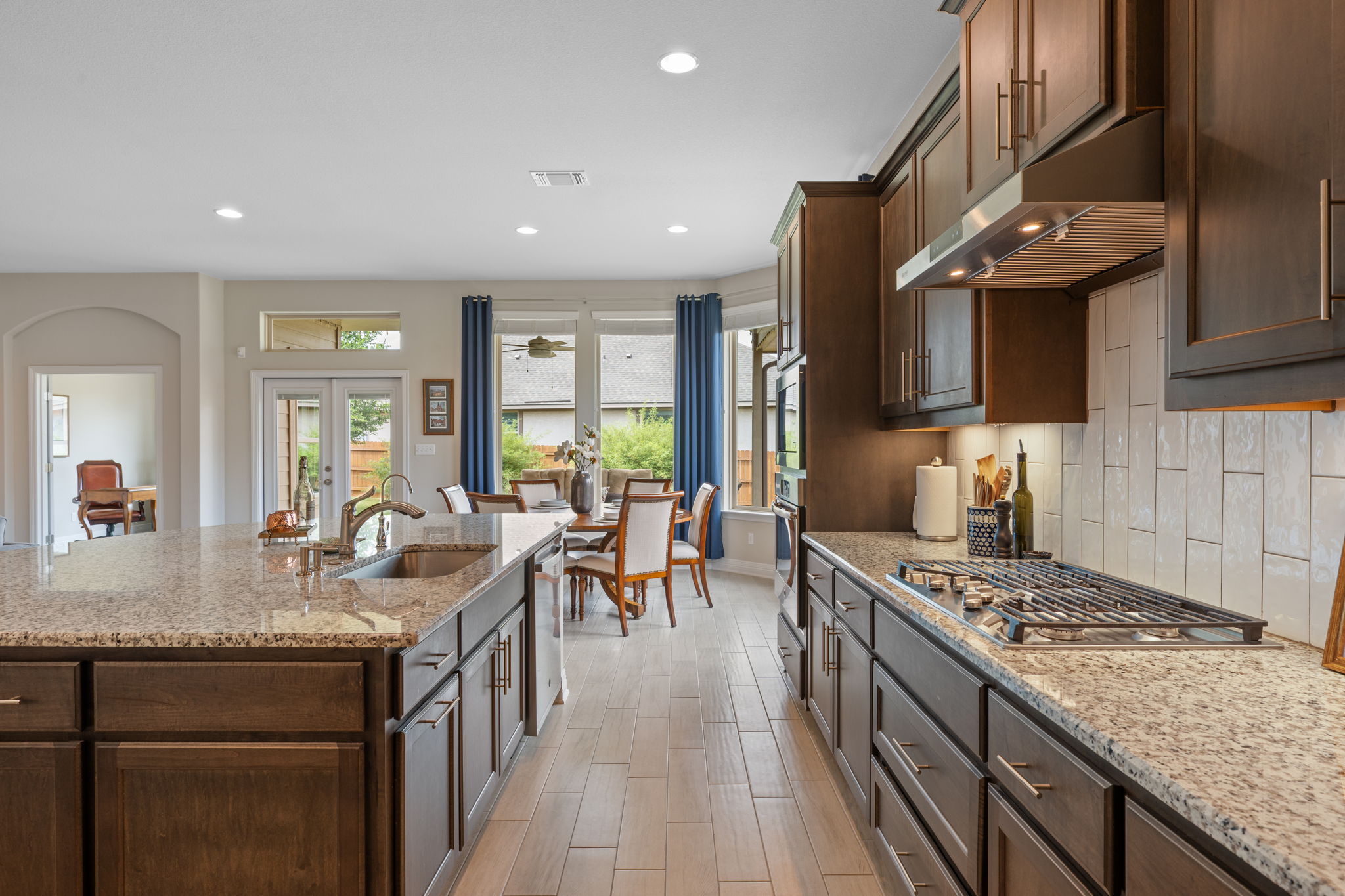 408 Bell Boot Pass Georgetown, TX 78626 - Photo 12 of 40 Modern kitchen with dark wood cabinetry, granite countertops, and a gas range