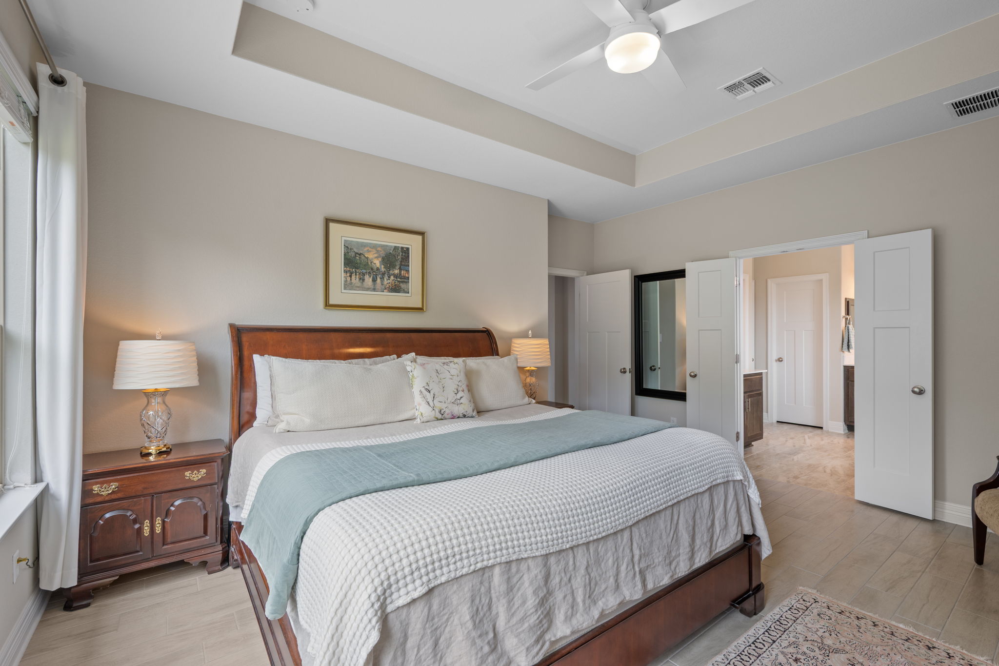 408 Bell Boot Pass Georgetown, TX 78626 - Photo 15 of 40 This spacious bedroom features a tray ceiling, a ceiling fan, and light-colored flooring