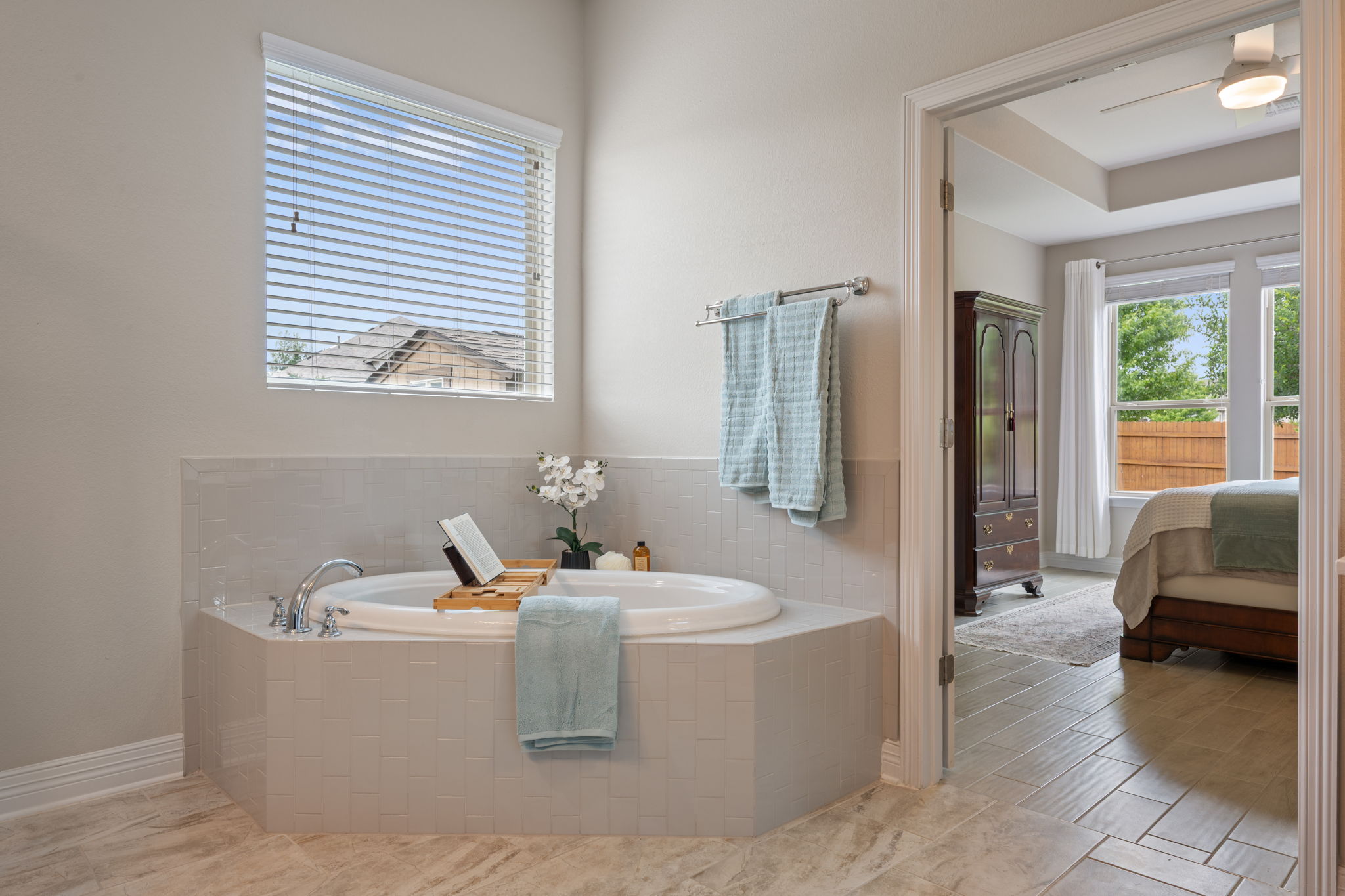408 Bell Boot Pass Georgetown, TX 78626 - Photo 17 of 40 The bathroom features a built-in corner bathtub with chrome fixtures and light-toned tile surround