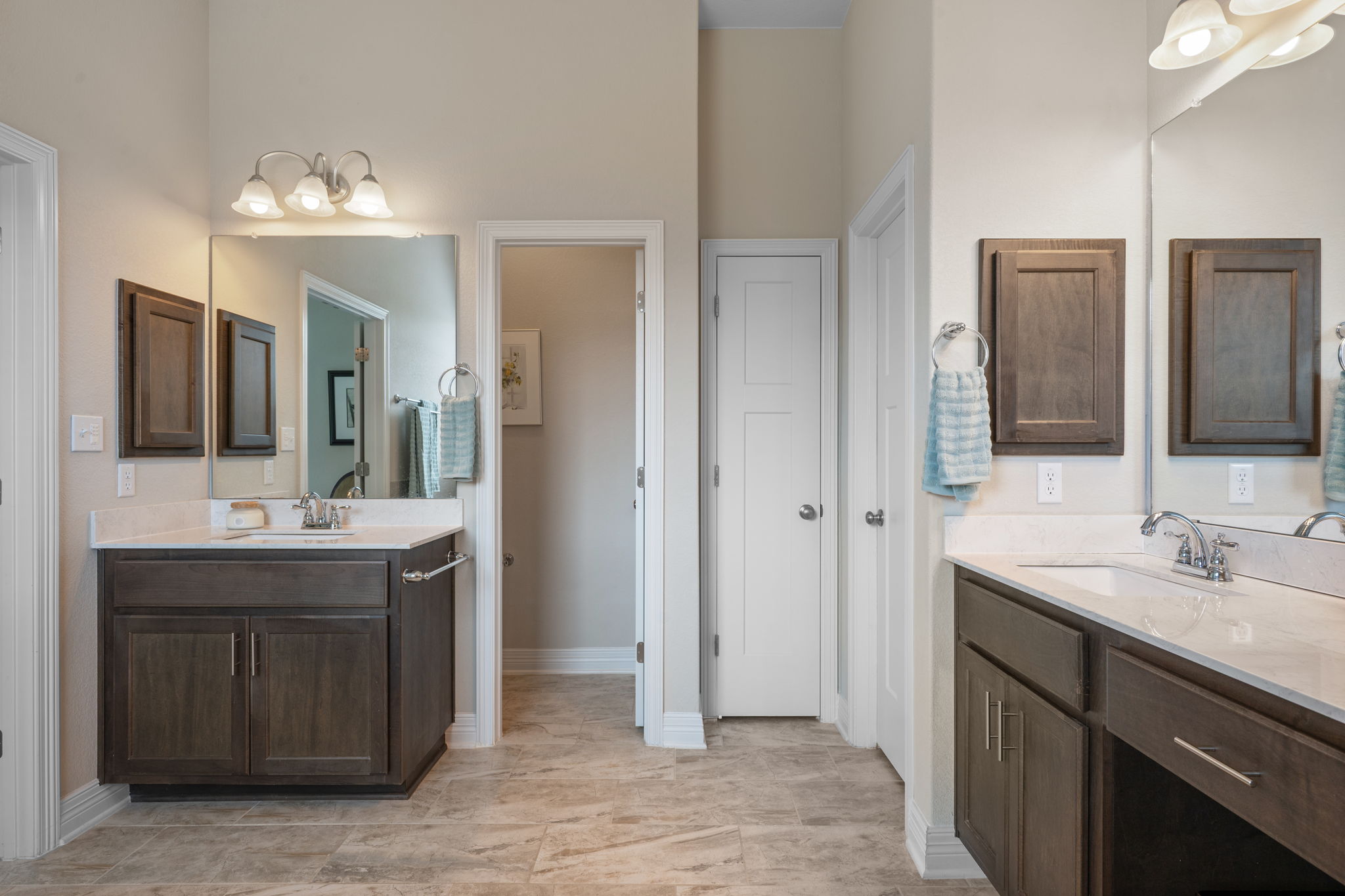 408 Bell Boot Pass Georgetown, TX 78626 - Photo 18 of 40 The bathroom features two dark wood vanities with white countertops and undermount sinks, set against light-colored walls