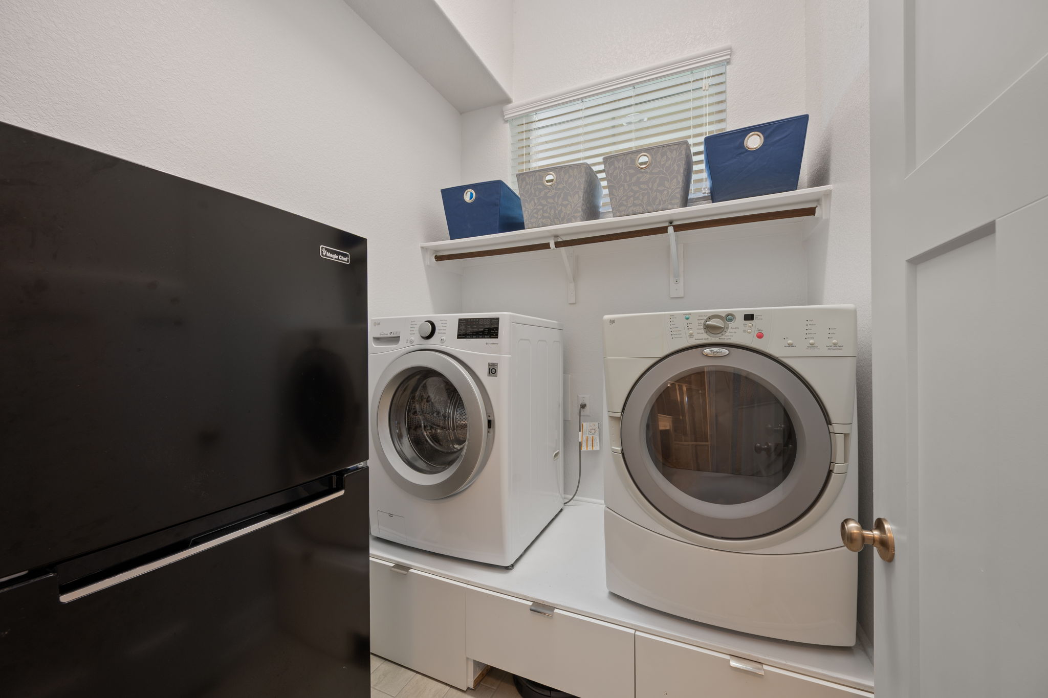 408 Bell Boot Pass Georgetown, TX 78626 - Photo 24 of 40 A dedicated laundry area featuring a front-loading washing machine and dryer, built-in cabinetry, and a window with blinds