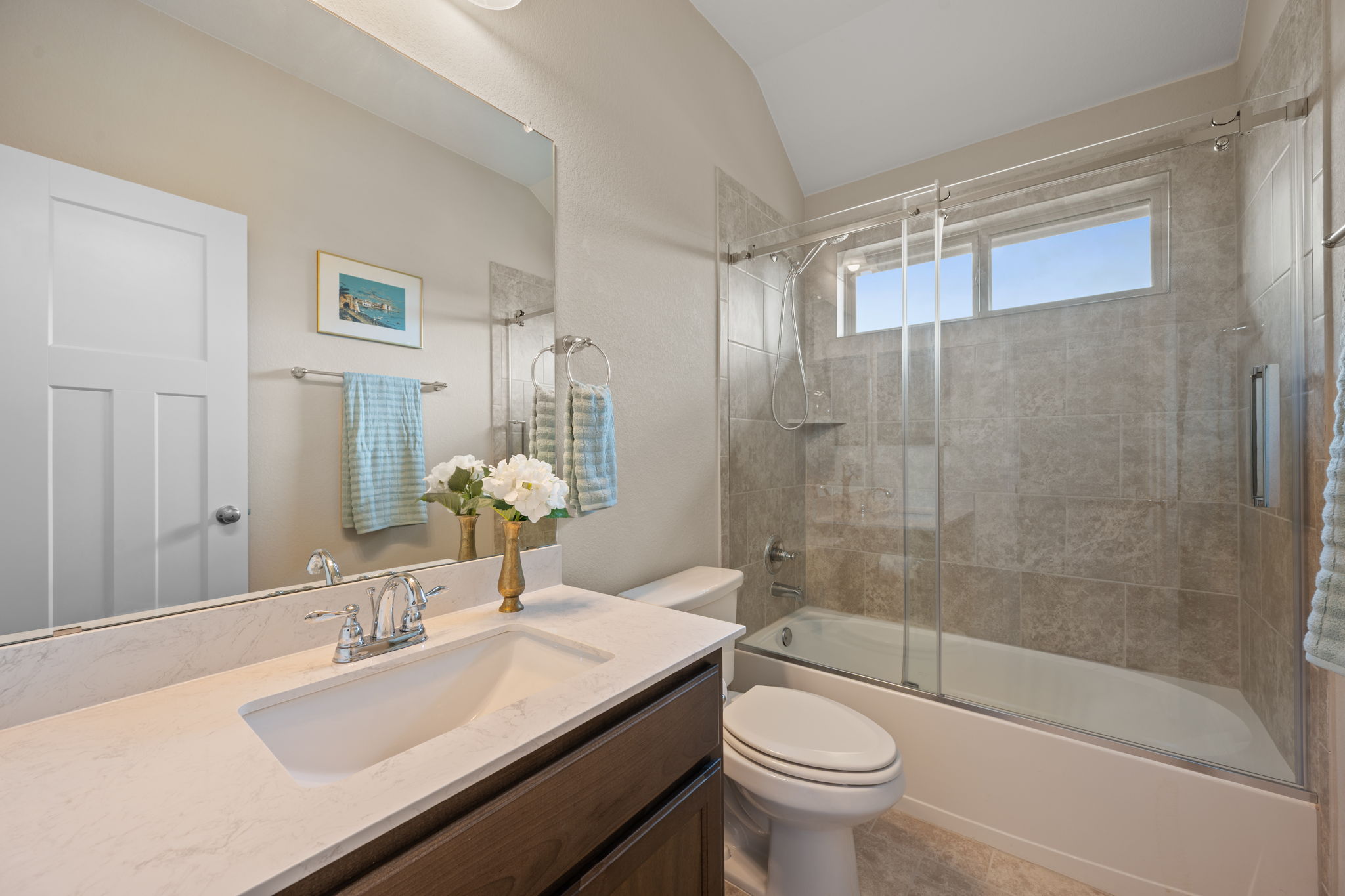 408 Bell Boot Pass Georgetown, TX 78626 - Photo 29 of 40 Bathroom featuring a vanity with an integrated sink and chrome faucet, a large mirror, and a shower-tub combination with tile surround and glass enclosure