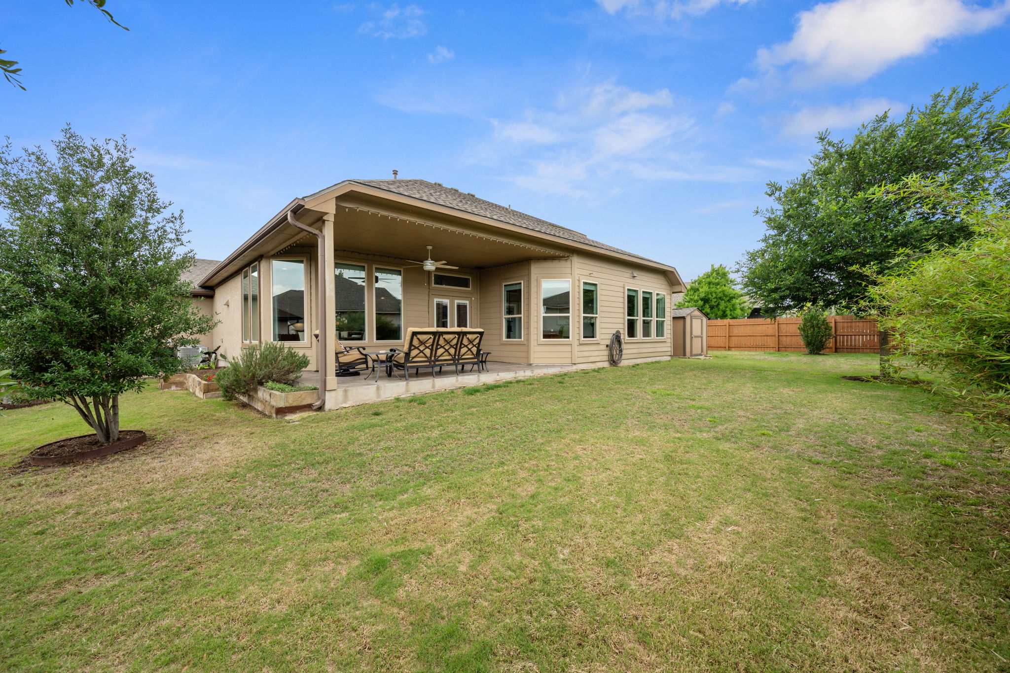 408 Bell Boot Pass Georgetown, TX 78626 - Photo 32 of 40 The property features an extensive yard with a lawn, mature trees, and a covered patio