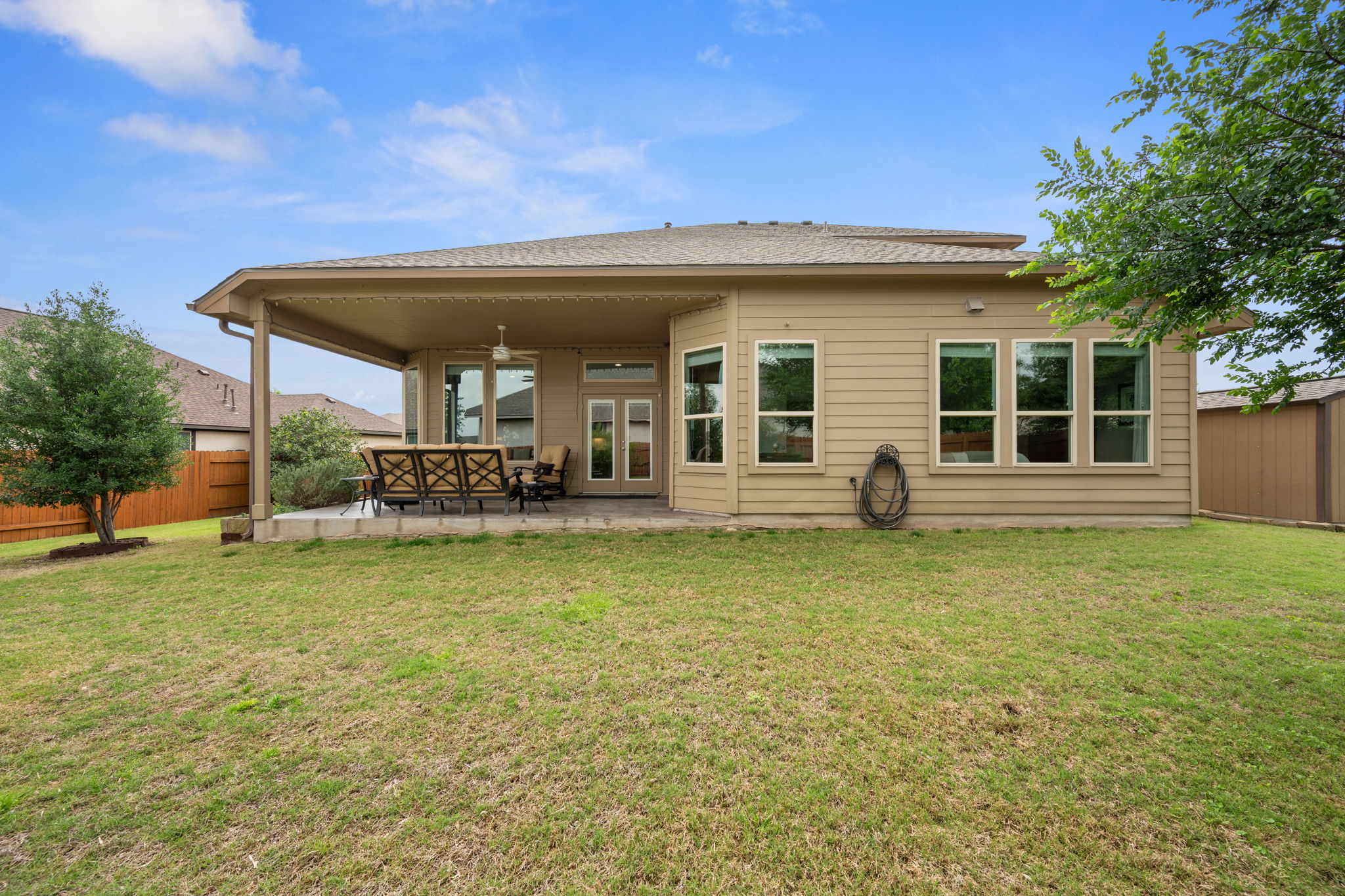 408 Bell Boot Pass Georgetown, TX 78626 - Photo 33 of 40 The property features a spacious rear yard with a lawn, a covered patio area, and a privacy fence