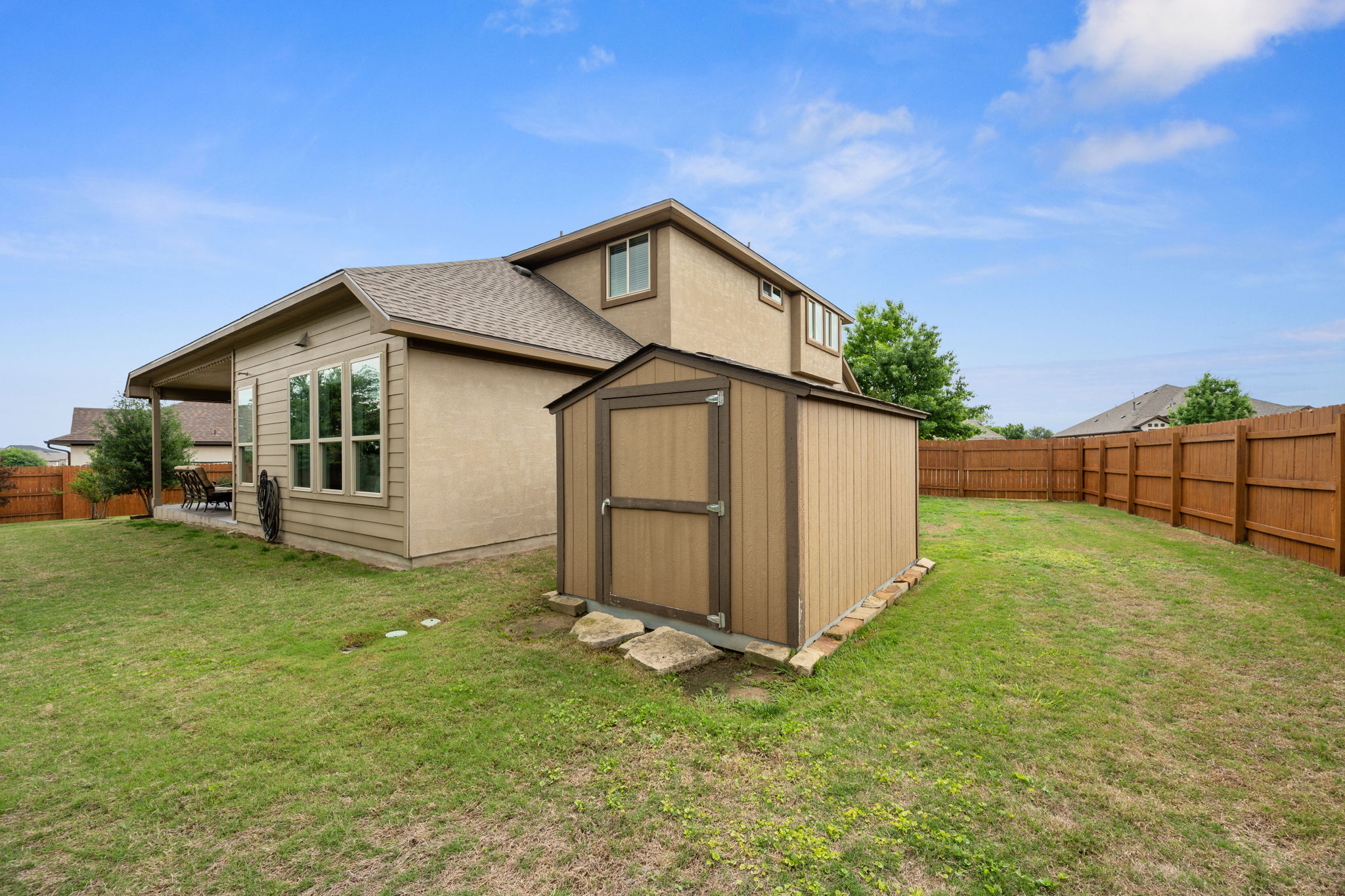 408 Bell Boot Pass Georgetown, TX 78626 - Photo 34 of 40 The property features a spacious backyard with a wooden storage shed and a privacy fence