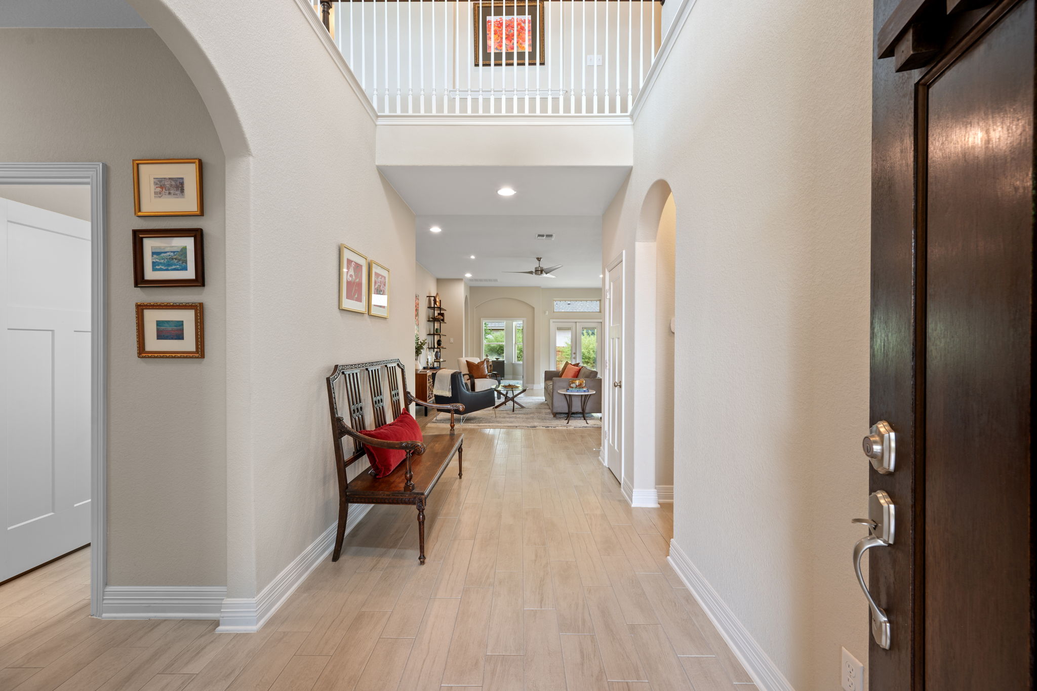 408 Bell Boot Pass Georgetown, TX 78626 - Photo 4 of 40 Inviting foyer with light-colored flooring, arched doorways, and a high ceiling with a balcony overlooking the space