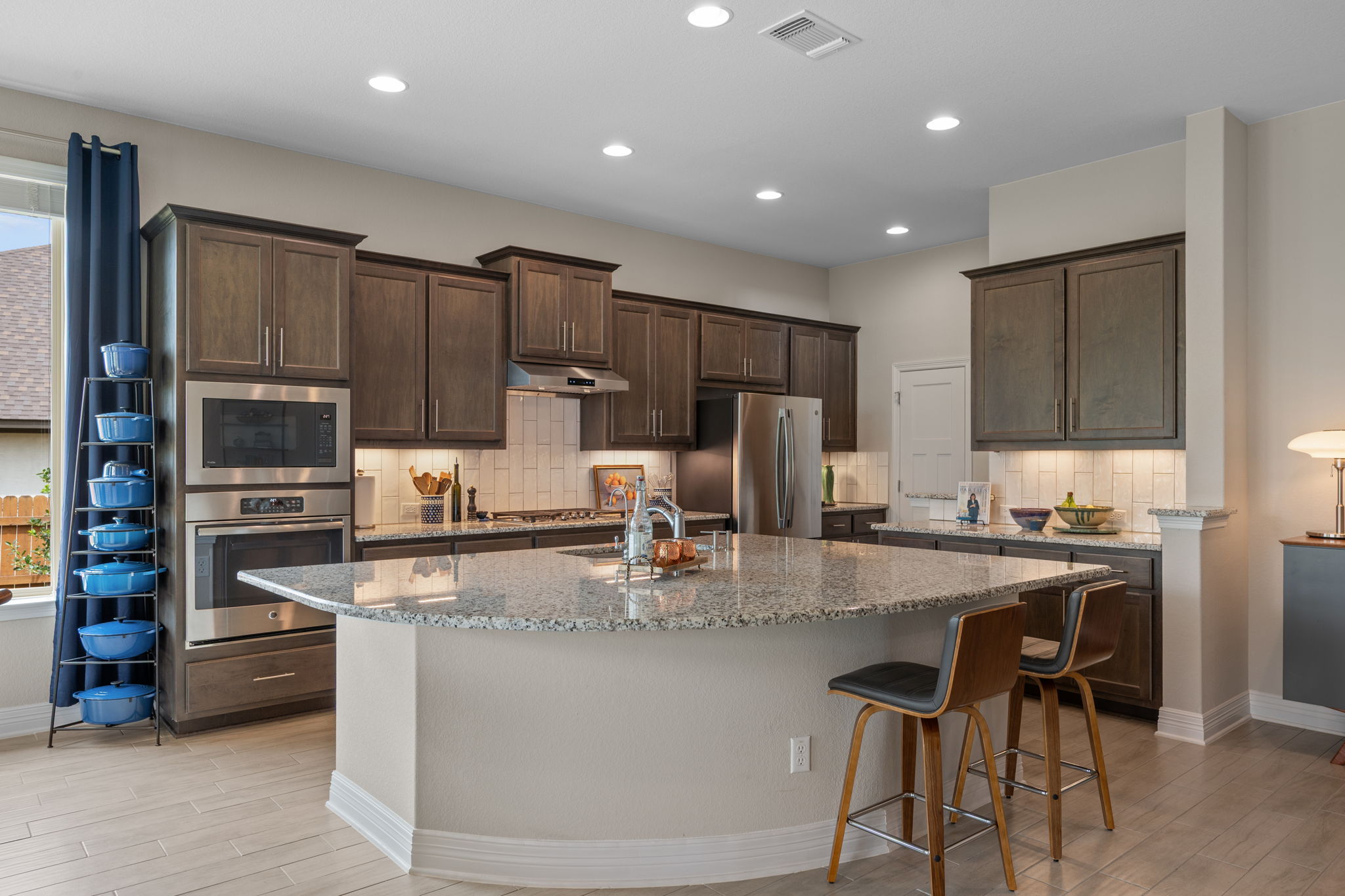 408 Bell Boot Pass Georgetown, TX 78626 - Photo 10 of 40 The kitchen features stainless steel appliances, dark wood cabinetry, and a light-colored tile backsplash
