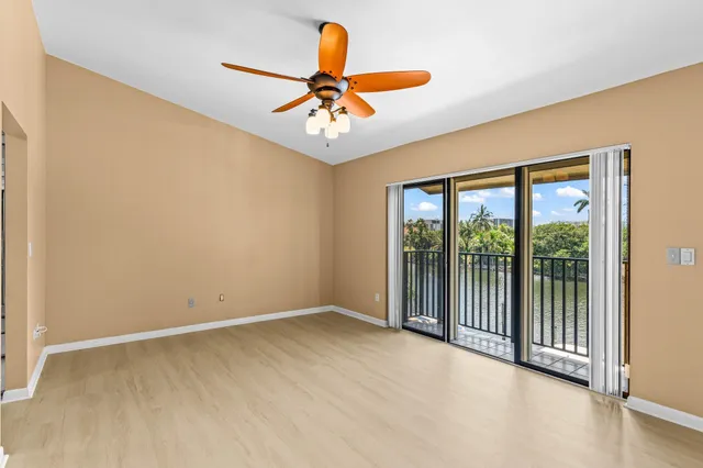 an empty room with a window and a ceiling fan