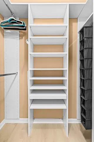 a view of walk in closet with clothes and shoes