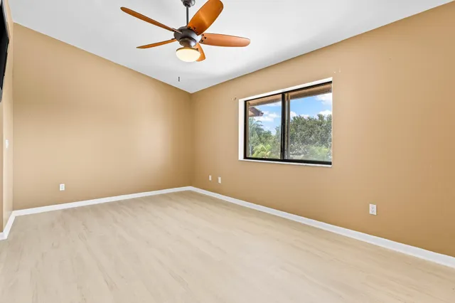 a view of a livingroom with wooden floor and a ceiling fan