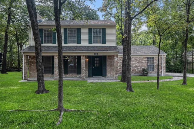 front view of a brick house with a yard