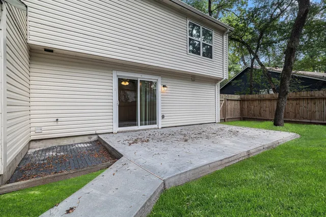 a view of a house with a small yard and a large tree