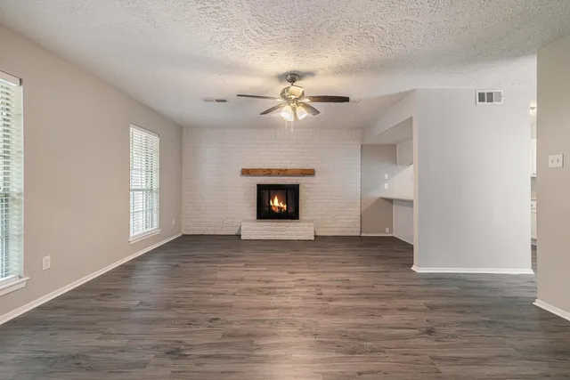 a view of an empty room with a fireplace and a window
