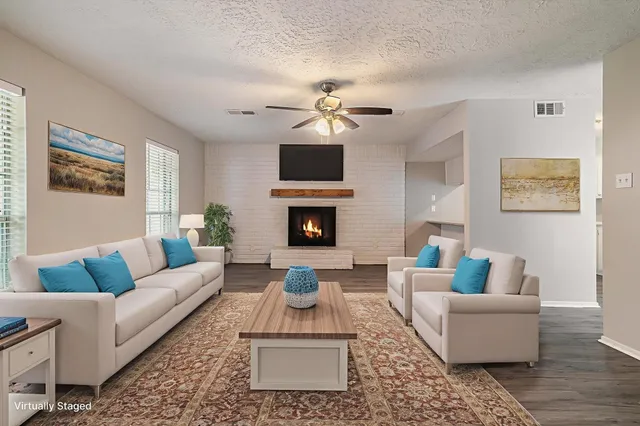 a living room with furniture a fireplace and a flat screen tv