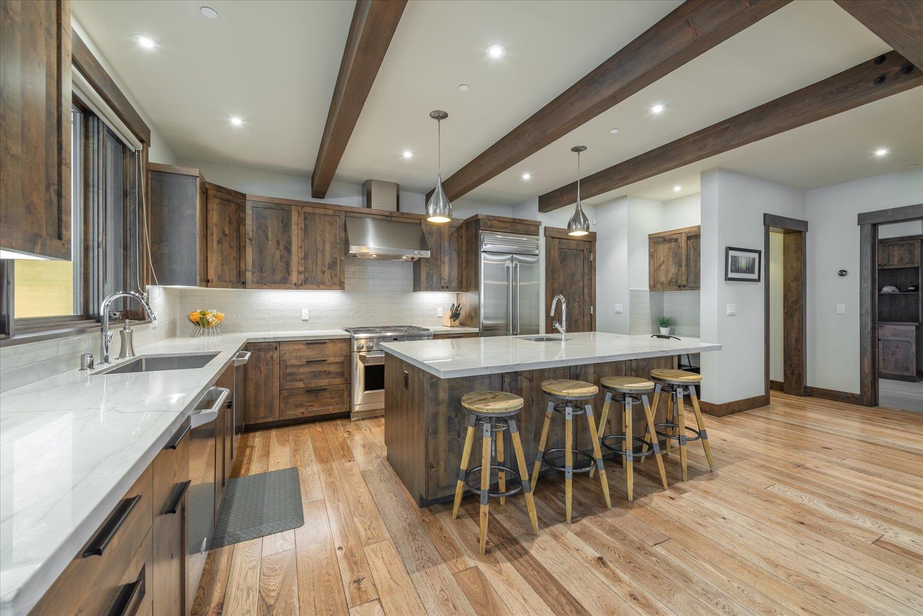 11460 Ghirard Road Truckee, CA 96161 - Photo 6 of 21 a large kitchen with wooden floor a sink a window and stainless steel appliances