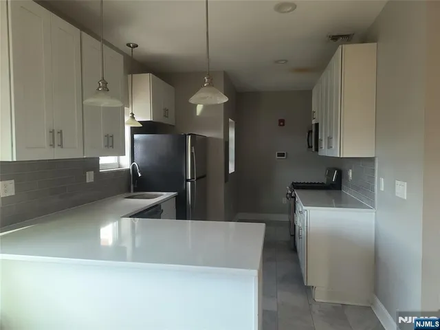 a modern kitchen with stainless steel appliances a refrigerator sink and microwave