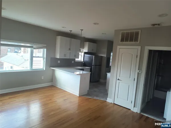 a kitchen with a refrigerator and a stove top oven