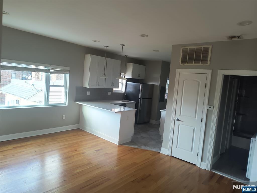 384 Fairview Avenue, Unit 3 Fairview, NJ 07022 - Photo 5 of 11 a kitchen with a refrigerator and a stove top oven