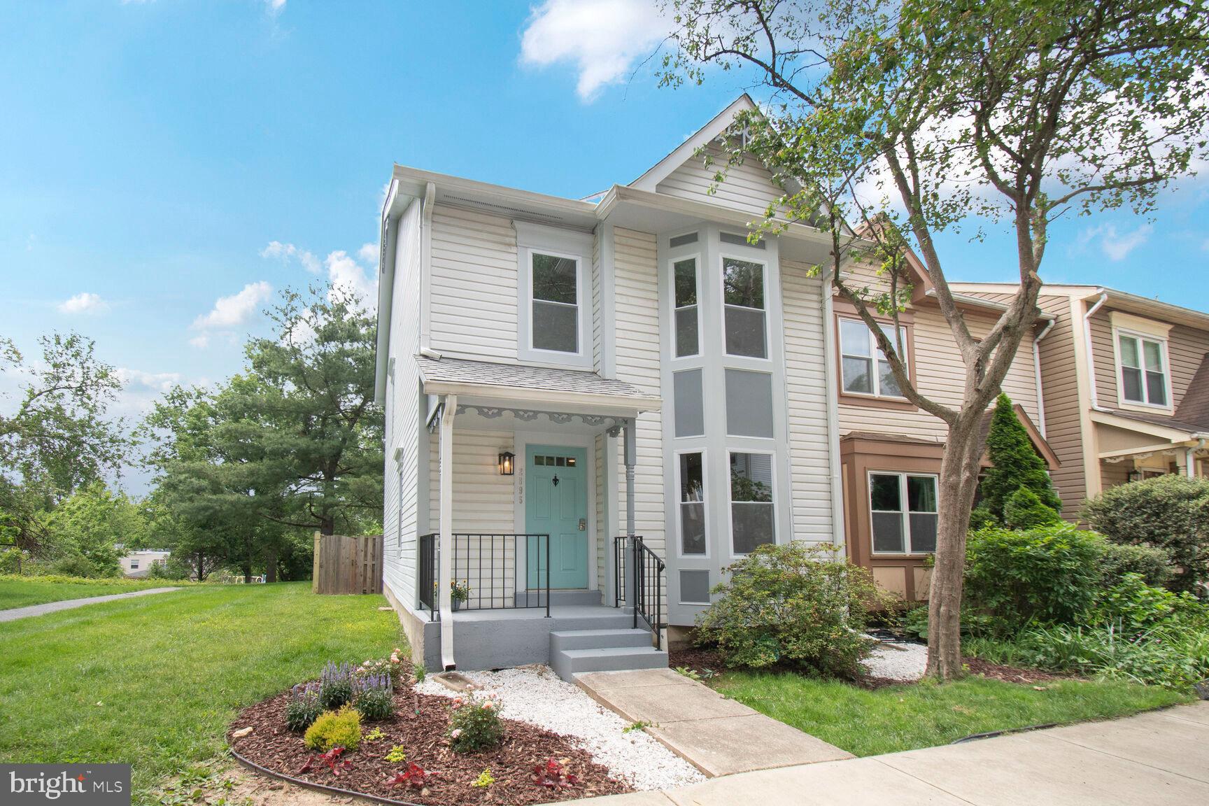 a front view of a house with a yard and potted plants