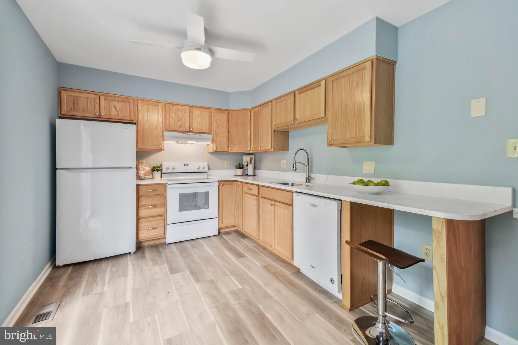 2895 Schoolhouse Circle Silver Spring, MD 20902 - Photo 12 of 33 a kitchen with a sink a window stainless steel appliances and cabinets