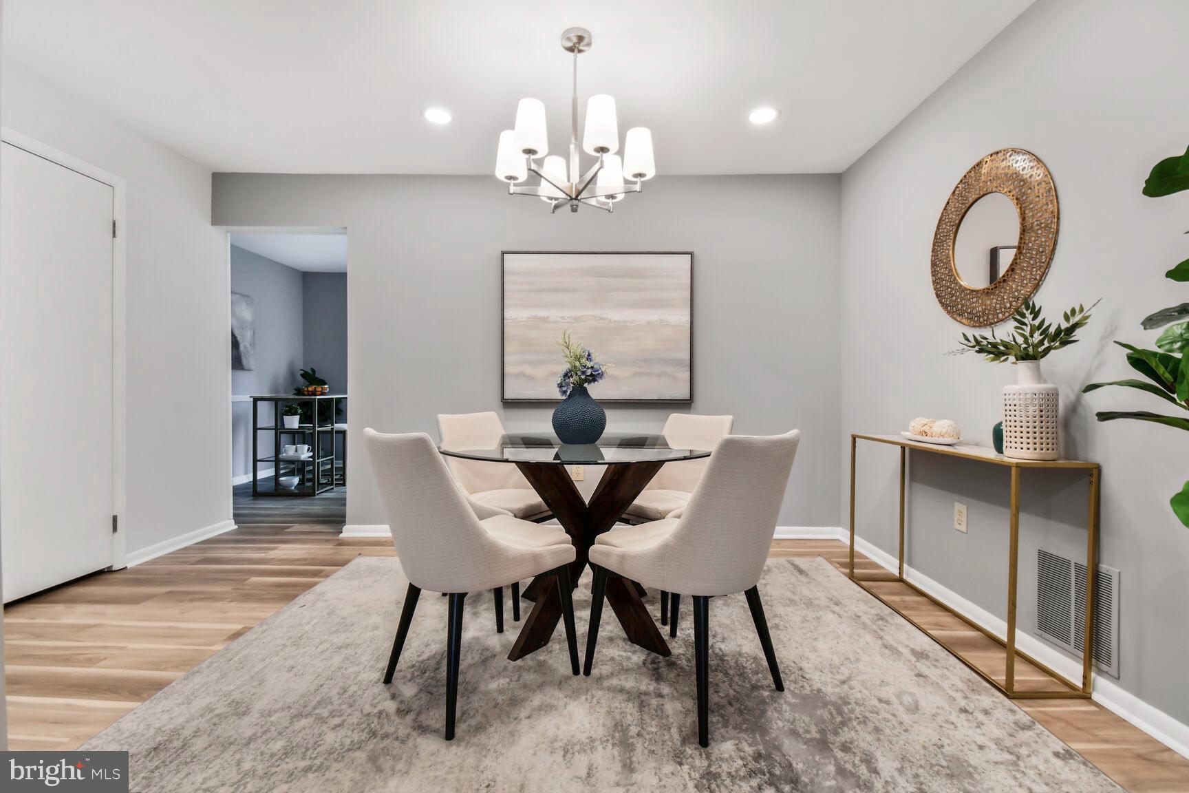 2895 Schoolhouse Circle Silver Spring, MD 20902 - Photo 7 of 33 a dining room with wooden floor a chandelier a wooden table and chairs