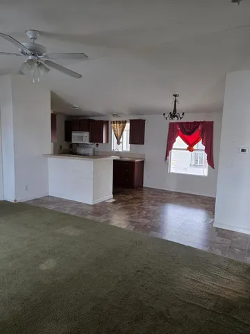 a view of kitchen with kitchen island a sink wooden floor and a window