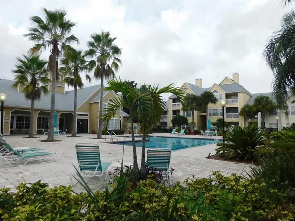 a view of a house with a yard and palm trees