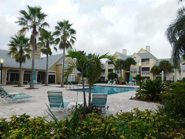 a view of a house with a yard and palm trees