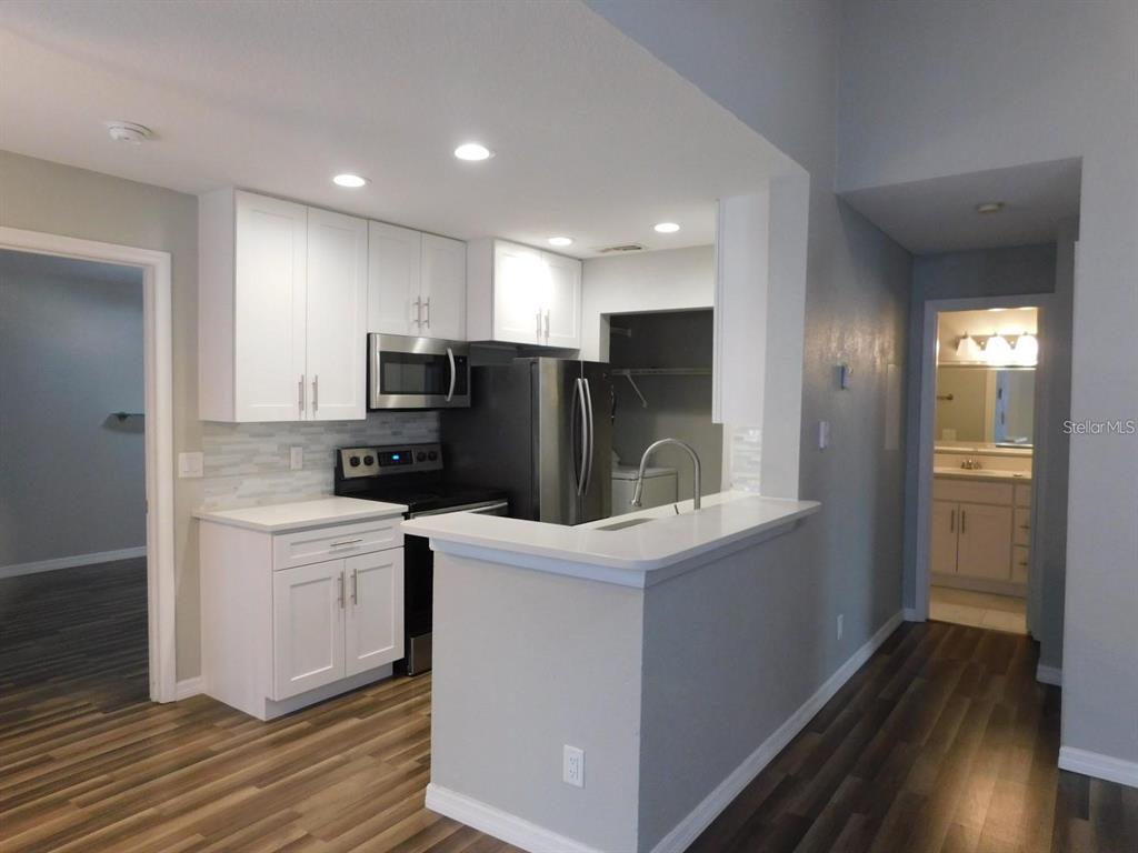 1077 South Hiawassee Road, Unit 823 Orlando, FL 32835 - Photo 3 of 29 a kitchen with a sink a refrigerator and wooden floor