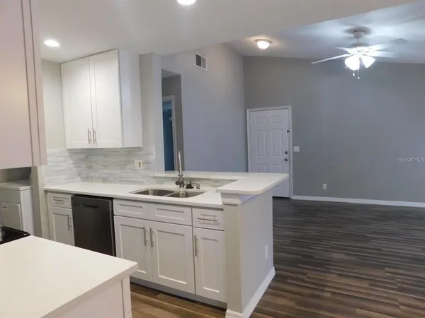 a kitchen with sink cabinets and chandelier