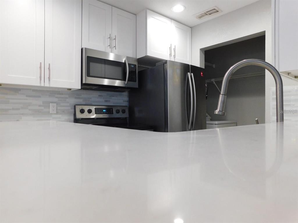 1077 South Hiawassee Road, Unit 823 Orlando, FL 32835 - Photo 7 of 29 a kitchen with stainless steel appliances granite countertop a refrigerator a stove a microwave and a sink