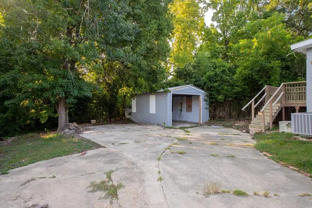 a view of a house with backyard and trees