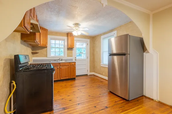 a kitchen with stainless steel appliances granite countertop a refrigerator a sink a stove and island