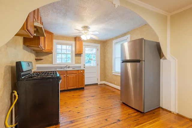 a kitchen with stainless steel appliances granite countertop a refrigerator a sink a stove and island