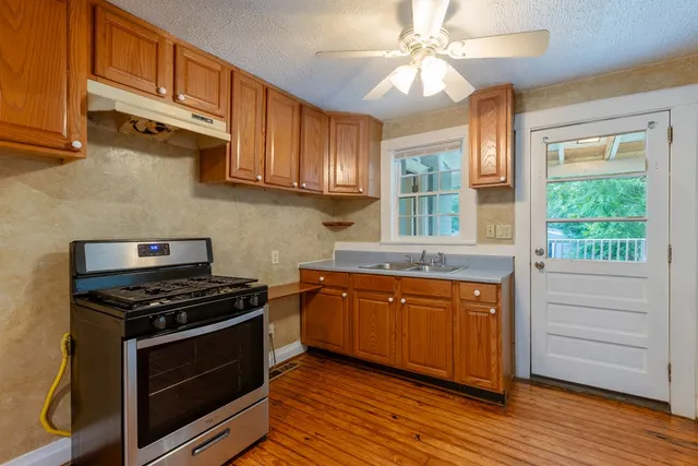 a kitchen with stainless steel appliances granite countertop a stove a sink and a microwave
