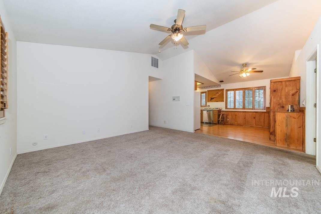 16517 Madison Road Nampa, ID 83687 - Photo 11 of 26 Unfurnished living room with a ceiling fan, light colored carpet, and vaulted ceiling