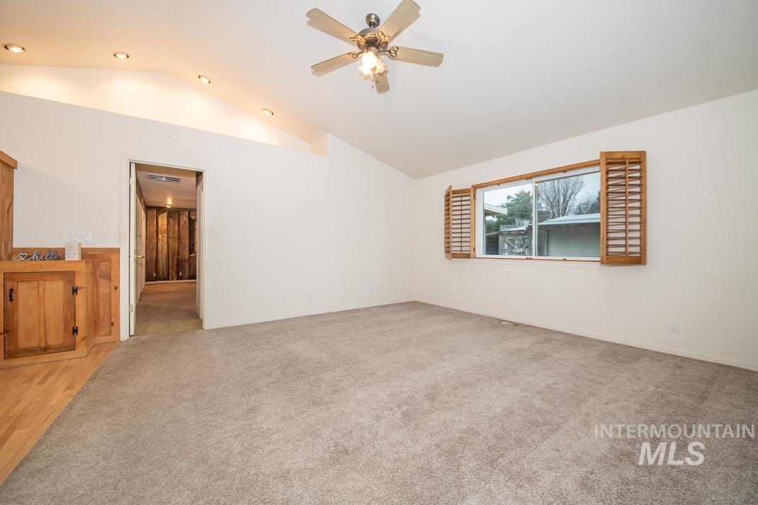 16517 Madison Road Nampa, ID 83687 - Photo 12 of 26 Empty room with lofted ceiling, light carpet, and a ceiling fan