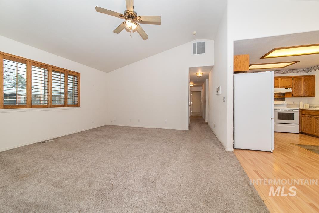 16517 Madison Road Nampa, ID 83687 - Photo 10 of 26 Unfurnished living room with ceiling fan, light carpet, and high vaulted ceiling