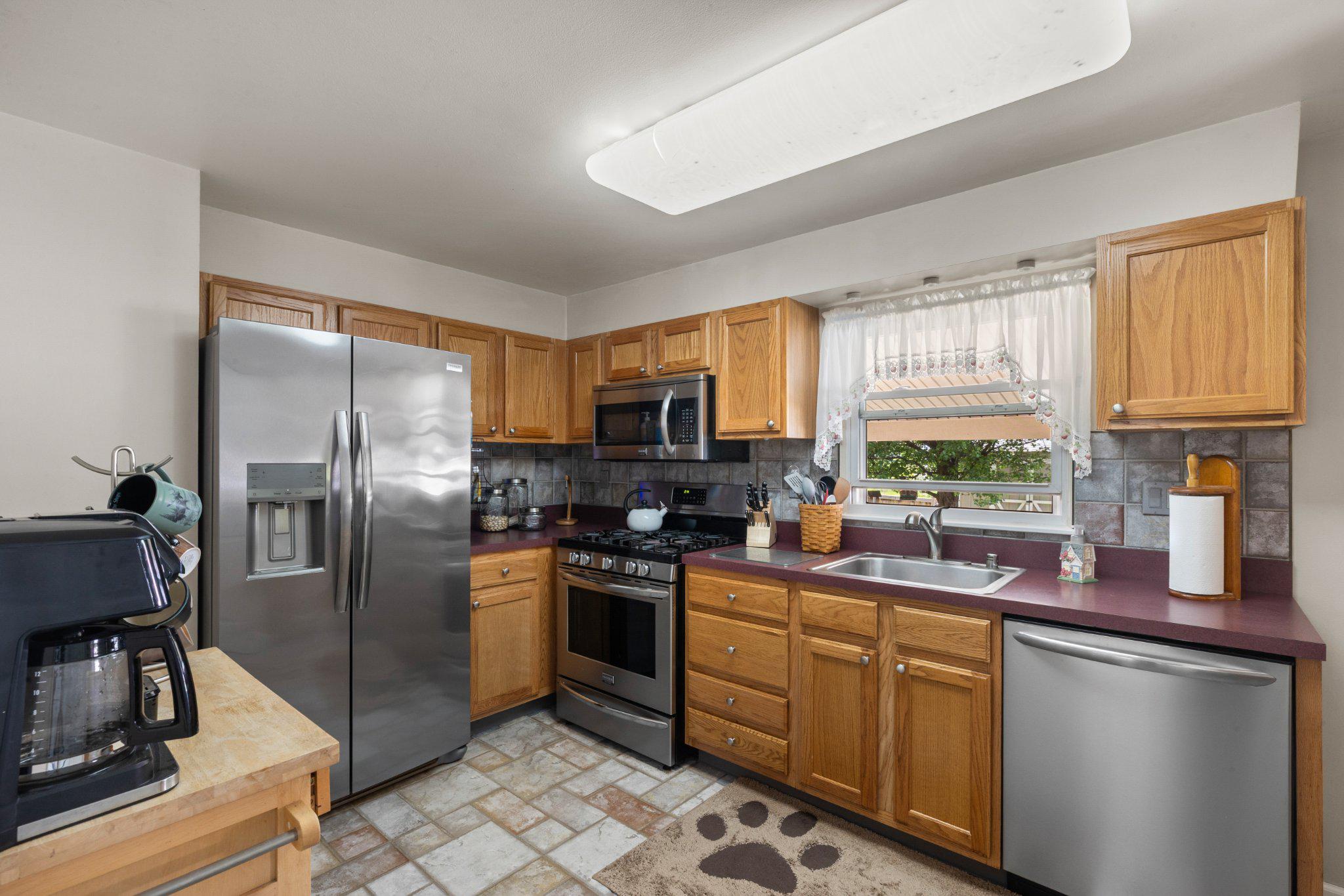5620 Chelwynd Road Halethorpe, MD 21227 - Photo 6 of 22 a kitchen with stainless steel appliances granite countertop a stove a sink dishwasher a refrigerator and cabinets with wooden floor