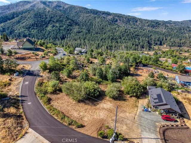 an aerial view of residential houses with outdoor space and trees