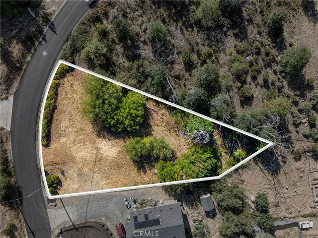 an aerial view of residential houses with outdoor space and trees