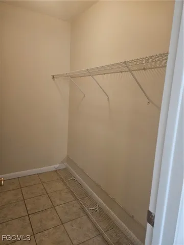 a view of an empty room and chandelier fan