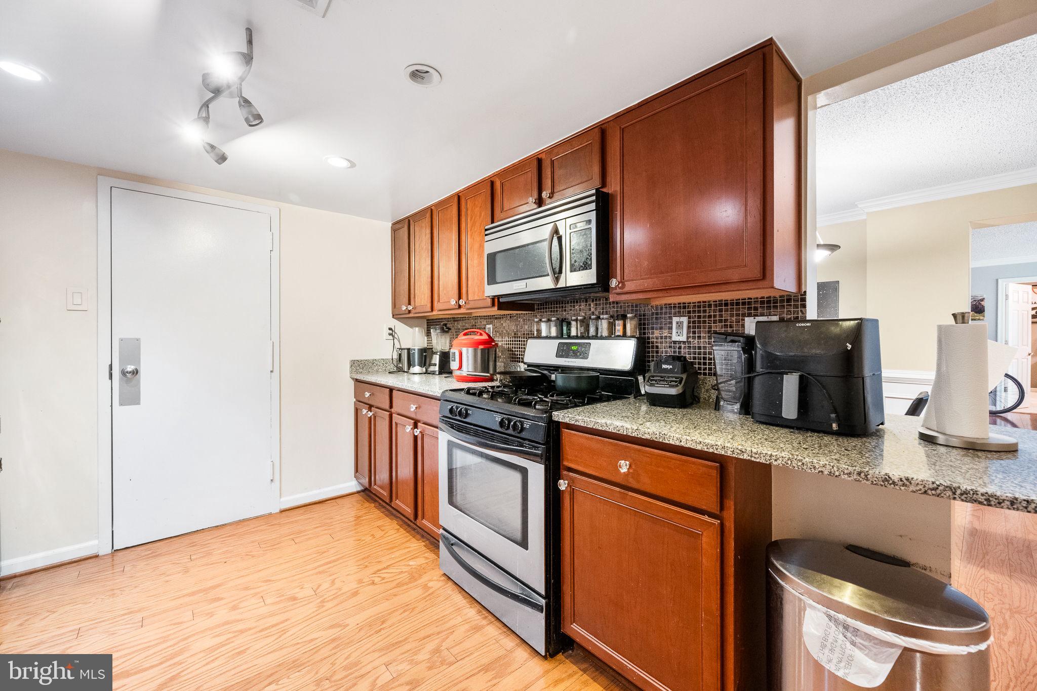 1515 South Arlington Ridge Road, Unit 303 Arlington, VA 22202 - Photo 18 of 34 a kitchen with stainless steel appliances granite countertop a stove a sink and a microwave