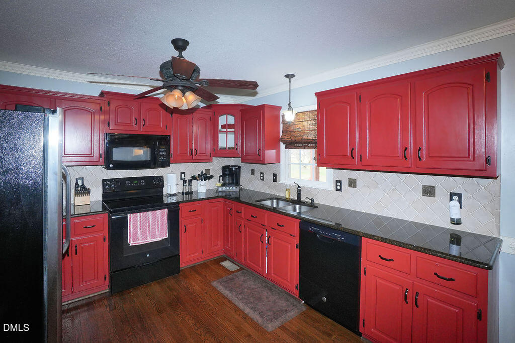 8877 Racine Road Pleasant Garden, NC 27313 - Photo 11 of 45 a kitchen with stainless steel appliances granite countertop a sink wooden cabinets and a granite counter top