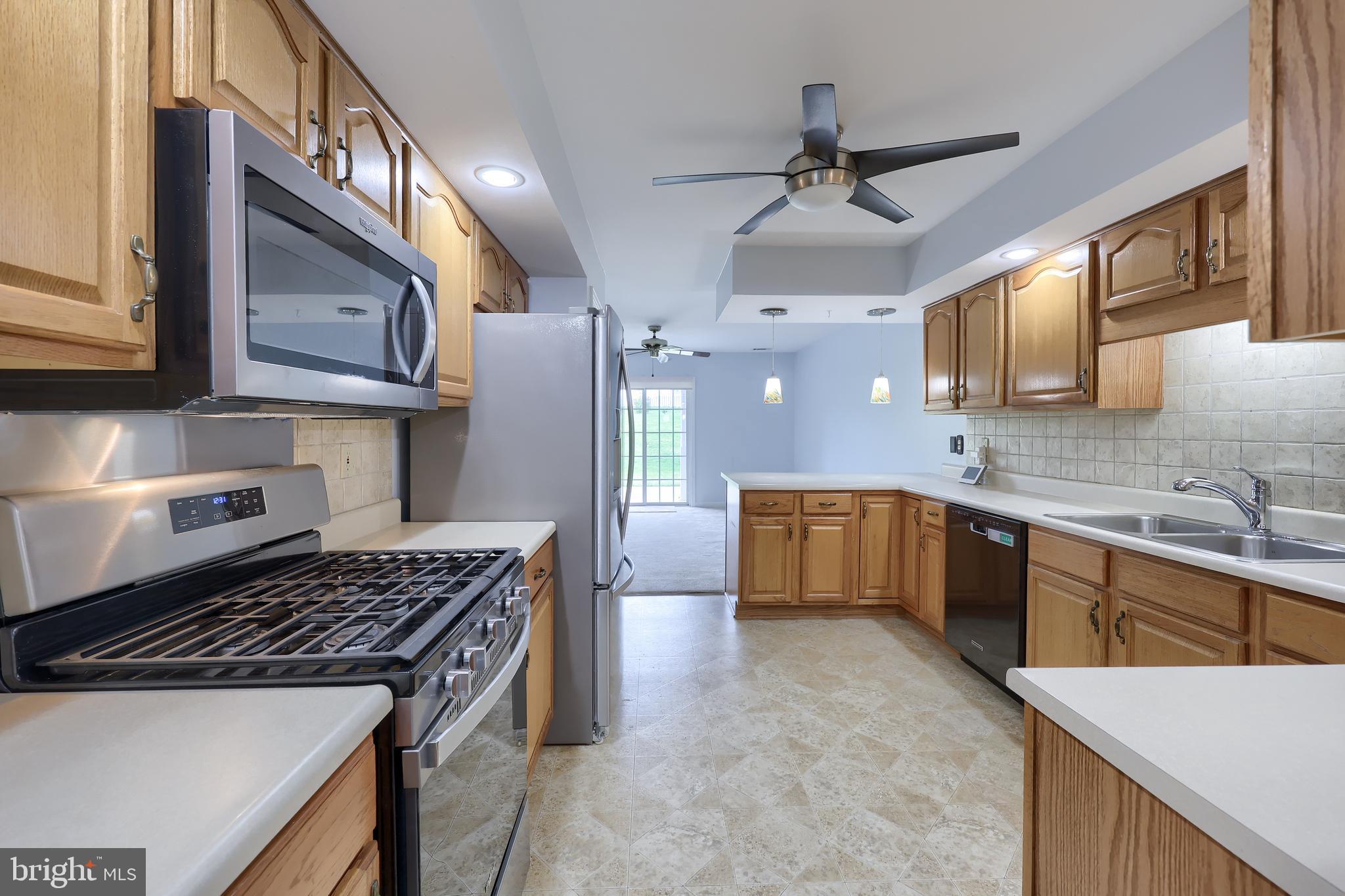 2002 Faversham Way York, PA 17402 - Photo 18 of 37 a kitchen with stainless steel appliances a sink a stove a refrigerator cabinets and a counter top space