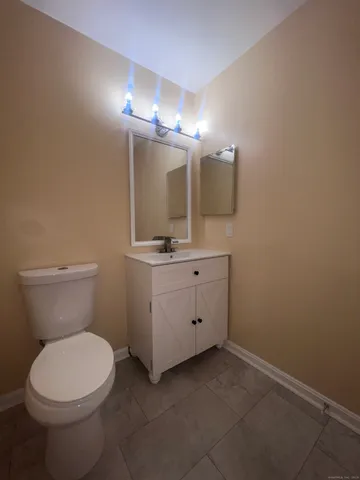 a bathroom with a toilet a sink and mirror