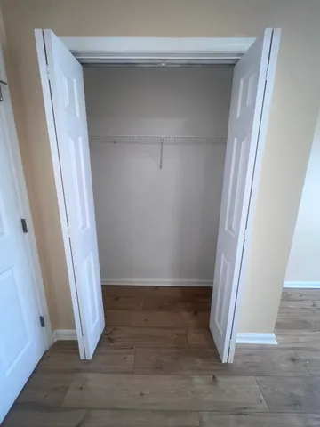 an empty room with wooden floor and staircase