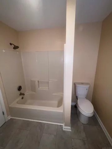 a walk in closet with wooden floor