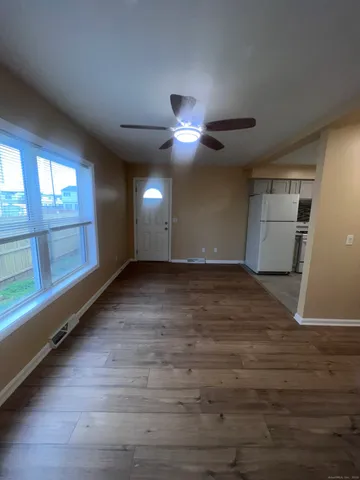 an empty room with wooden floor and windows