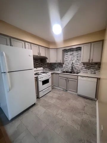 a kitchen with granite countertop appliances a sink and cabinets